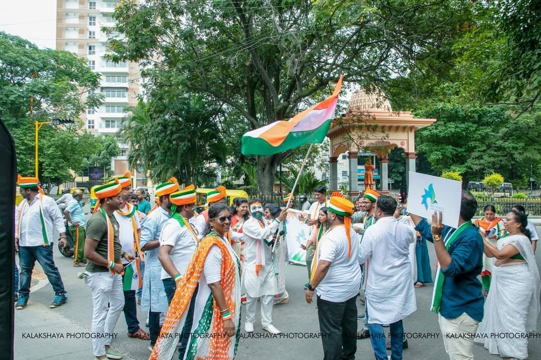 Walkers gathering at the start point with tricolour turbans and flags